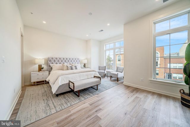 a bedroom with a bed and a large window