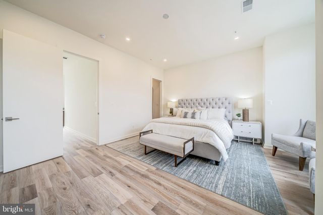 a spacious bedroom with a bed and a wooden floor