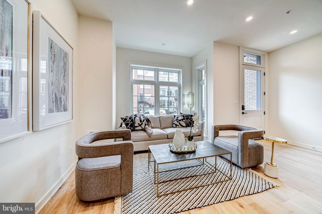 a living room with furniture a large window and a rug