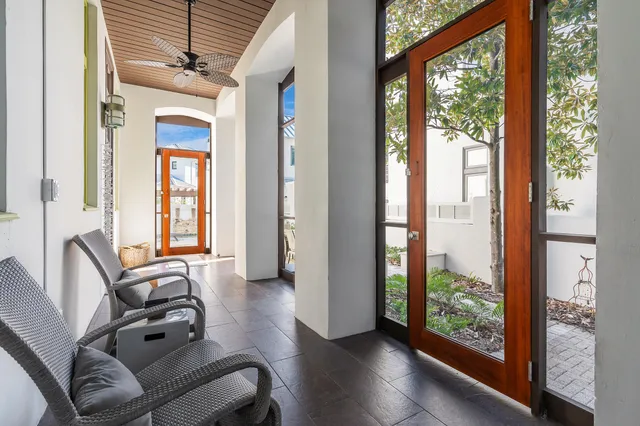 an entryway with wooden floor mirror and windows