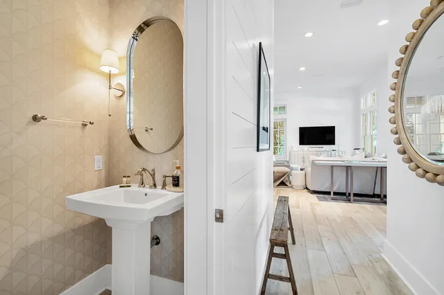 a kitchen with stainless steel appliances kitchen island granite countertop a stove a sink a refrigerator and white cabinets with wooden floor