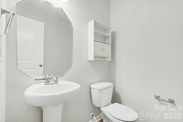a bathroom with a sink a toilet and mirror