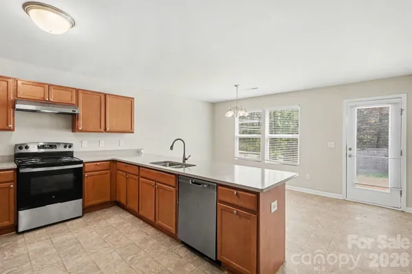 a kitchen with stainless steel appliances granite countertop a sink stove and cabinets