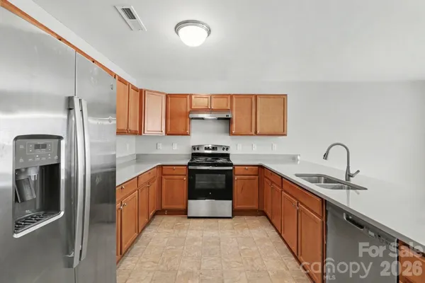 a kitchen with stainless steel appliances granite countertop a sink stove and refrigerator