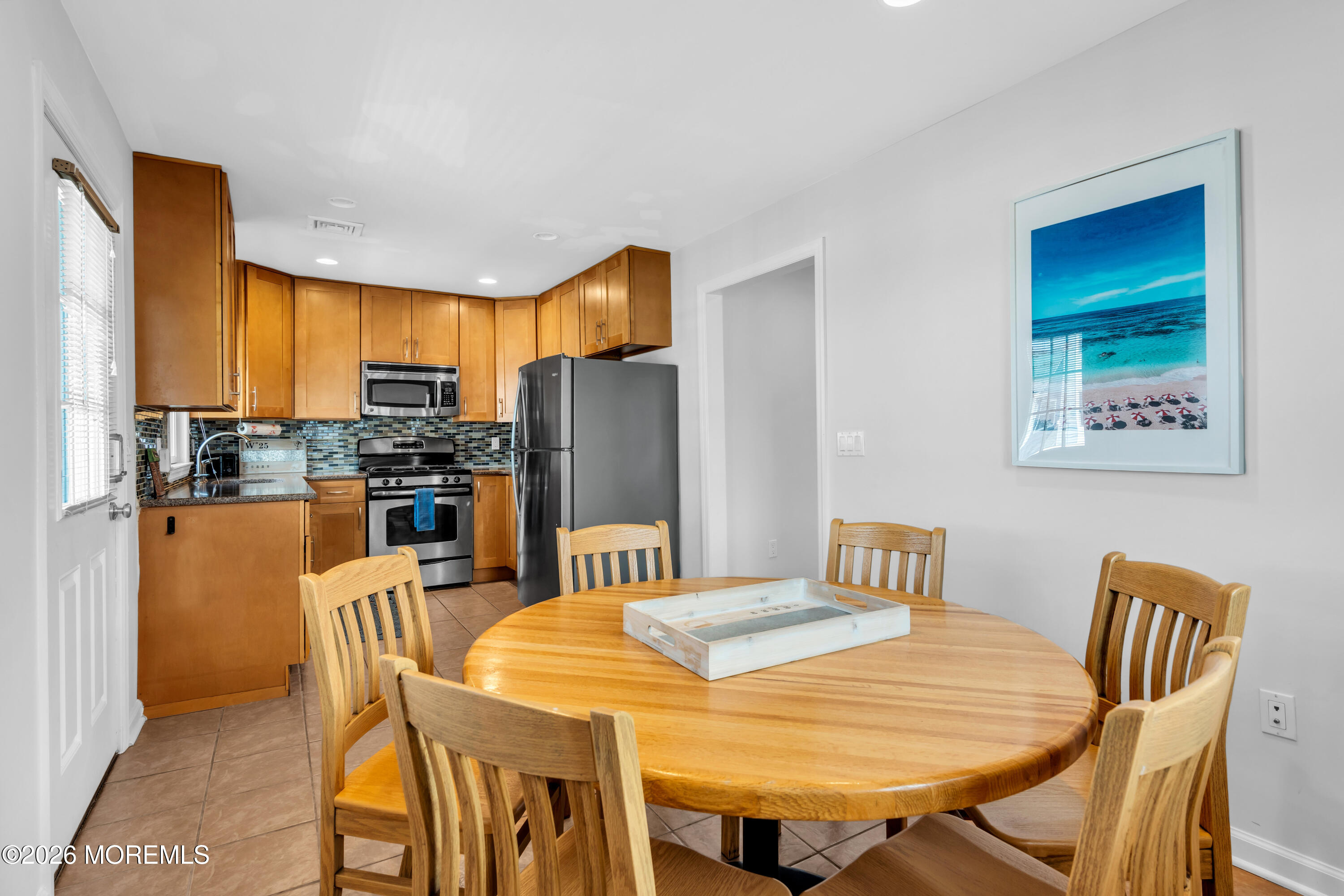 27 Arnold Avenue Point Pleasant Beach, NJ 08742 - Photo 22 of 48 a kitchen with stainless steel appliances wooden floor dining table and chairs