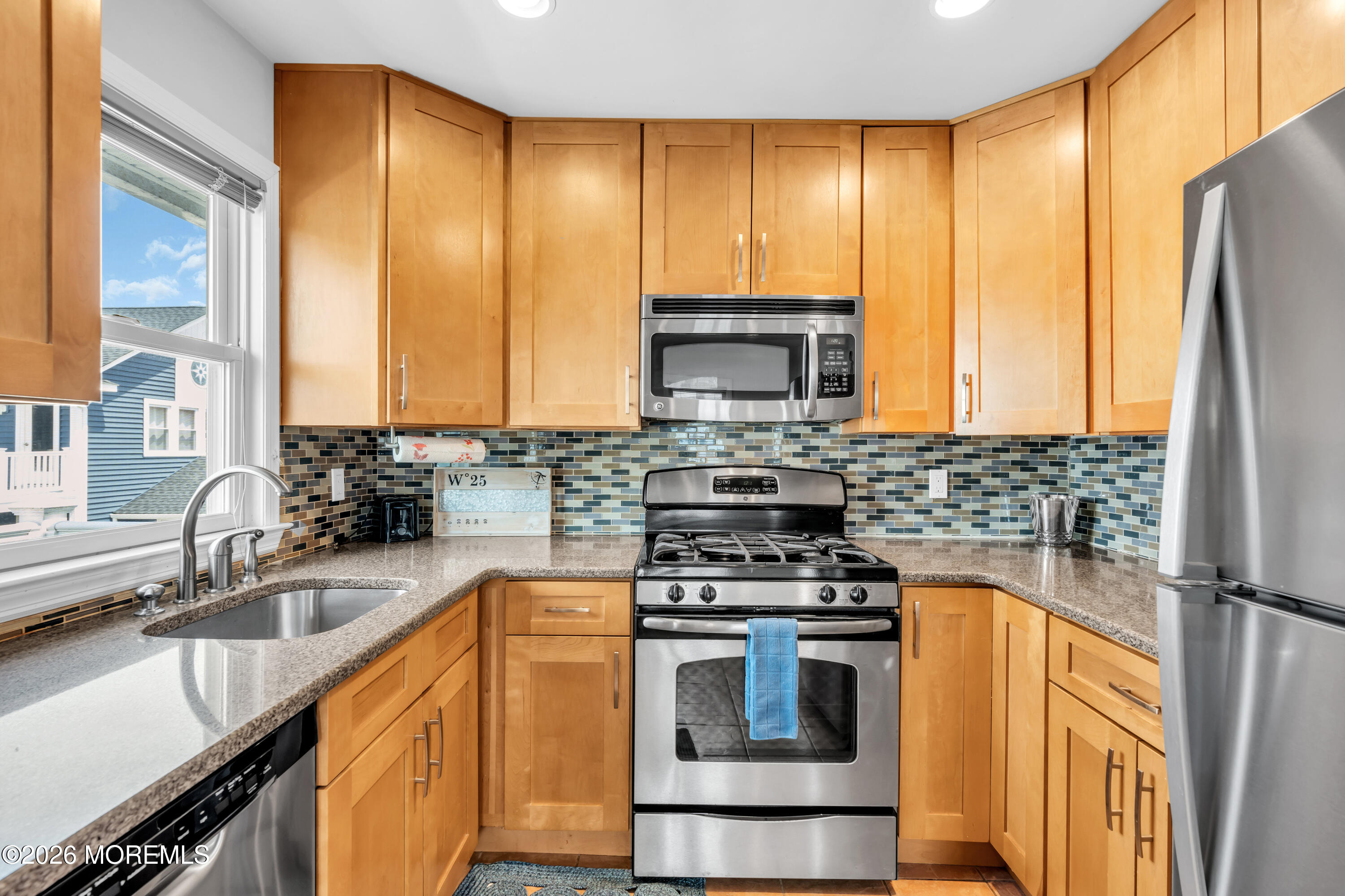 27 Arnold Avenue Point Pleasant Beach, NJ 08742 - Photo 25 of 48 a kitchen with a sink a counter top space cabinets stainless steel appliances and a window