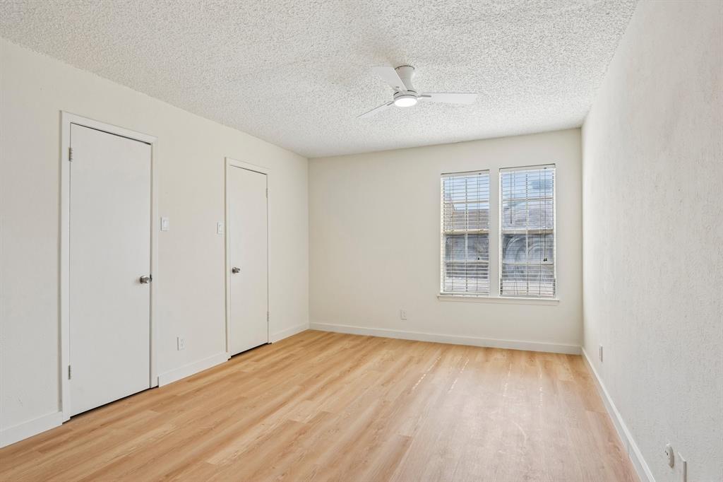 5300 Keller Springs Road, Unit 2055 Dallas, TX 75248 - Photo 7 of 24 Spacious room featuring light wood-finish flooring, a contemporary ceiling fan, and two large windows with blinds