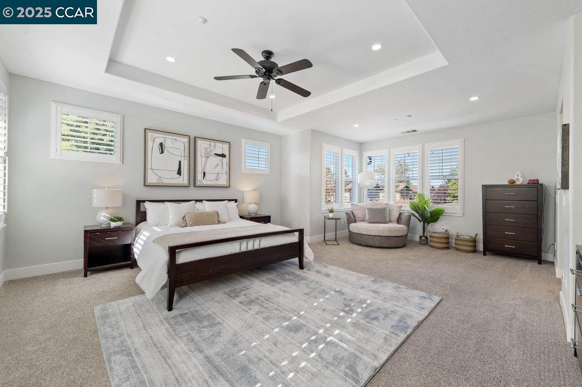 5656 Stockton Loop Livermore, CA 94550 - Photo 21 of 37 a spacious bedroom with a bed a couch and a window