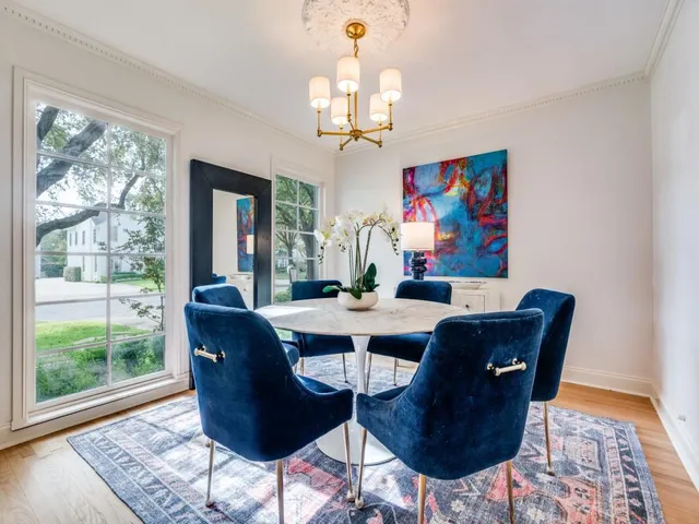 a dining room with wooden floor a chandelier a wooden table and chairs