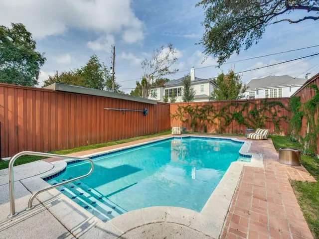a backyard with table and chairs and potted plants