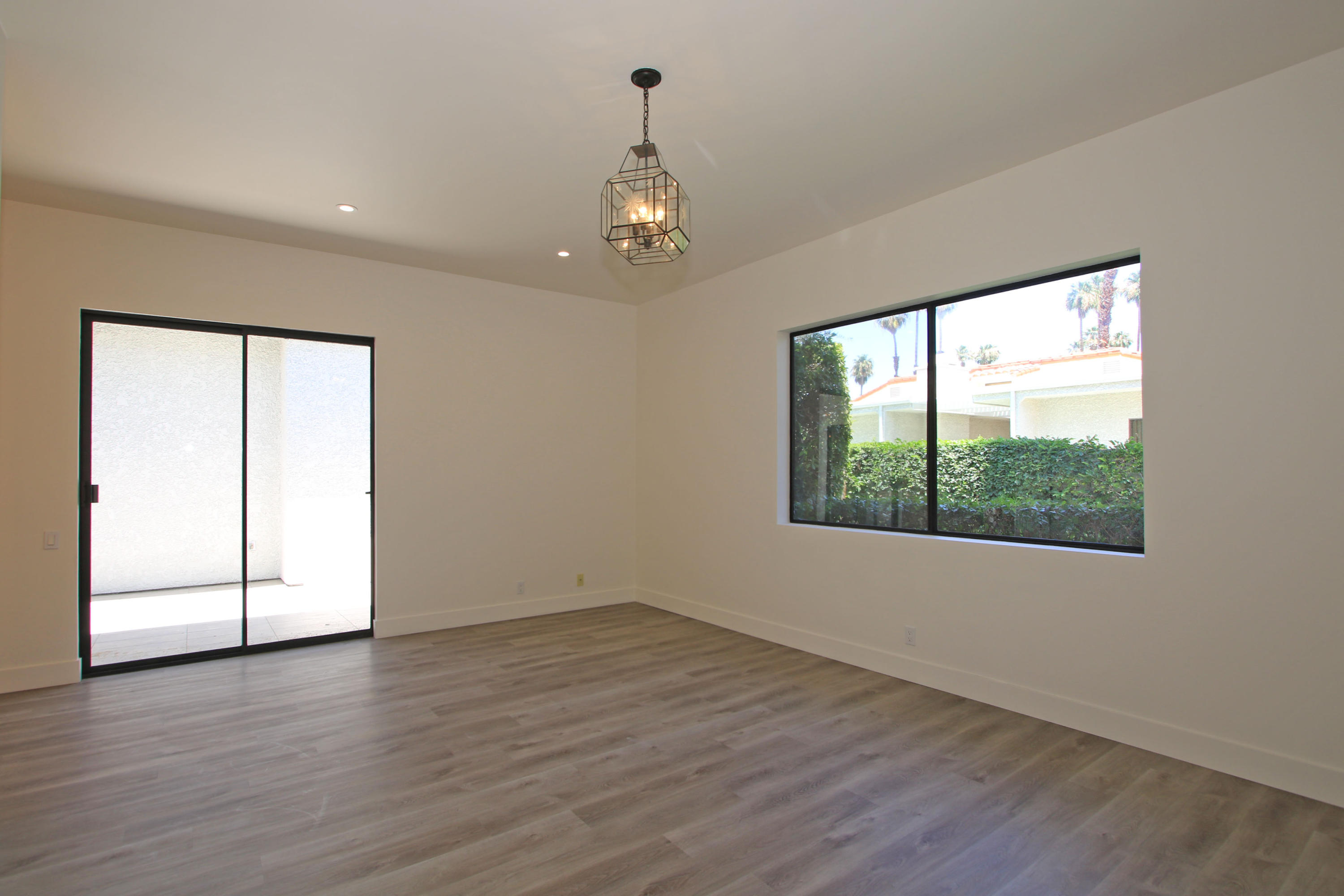 87 Magdalena Drive Rancho Mirage, CA 92270 - Photo 29 of 64 an empty room with wooden floor chandelier and windows