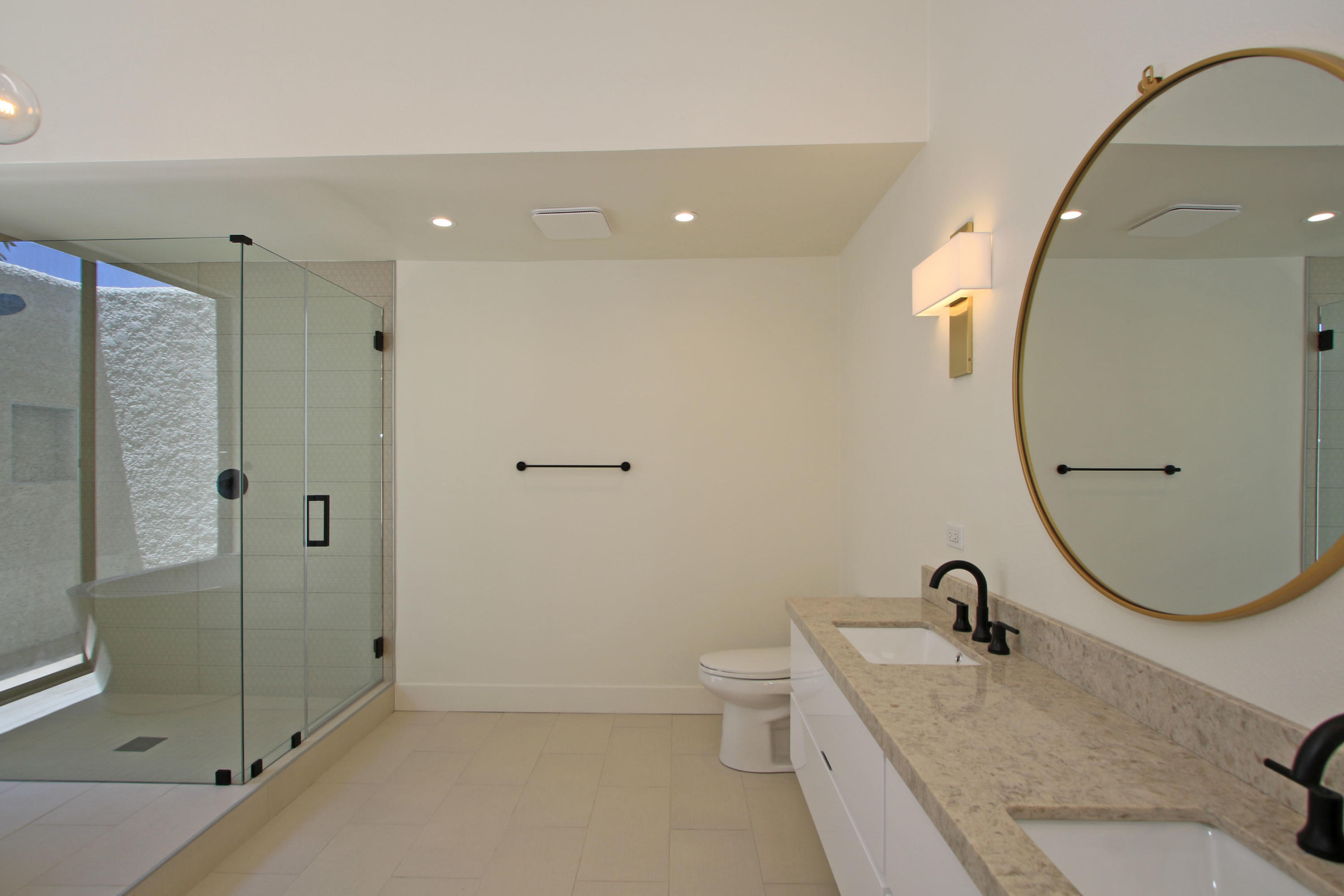 87 Magdalena Drive Rancho Mirage, CA 92270 - Photo 32 of 64 a bathroom with a granite countertop sink a toilet and shower