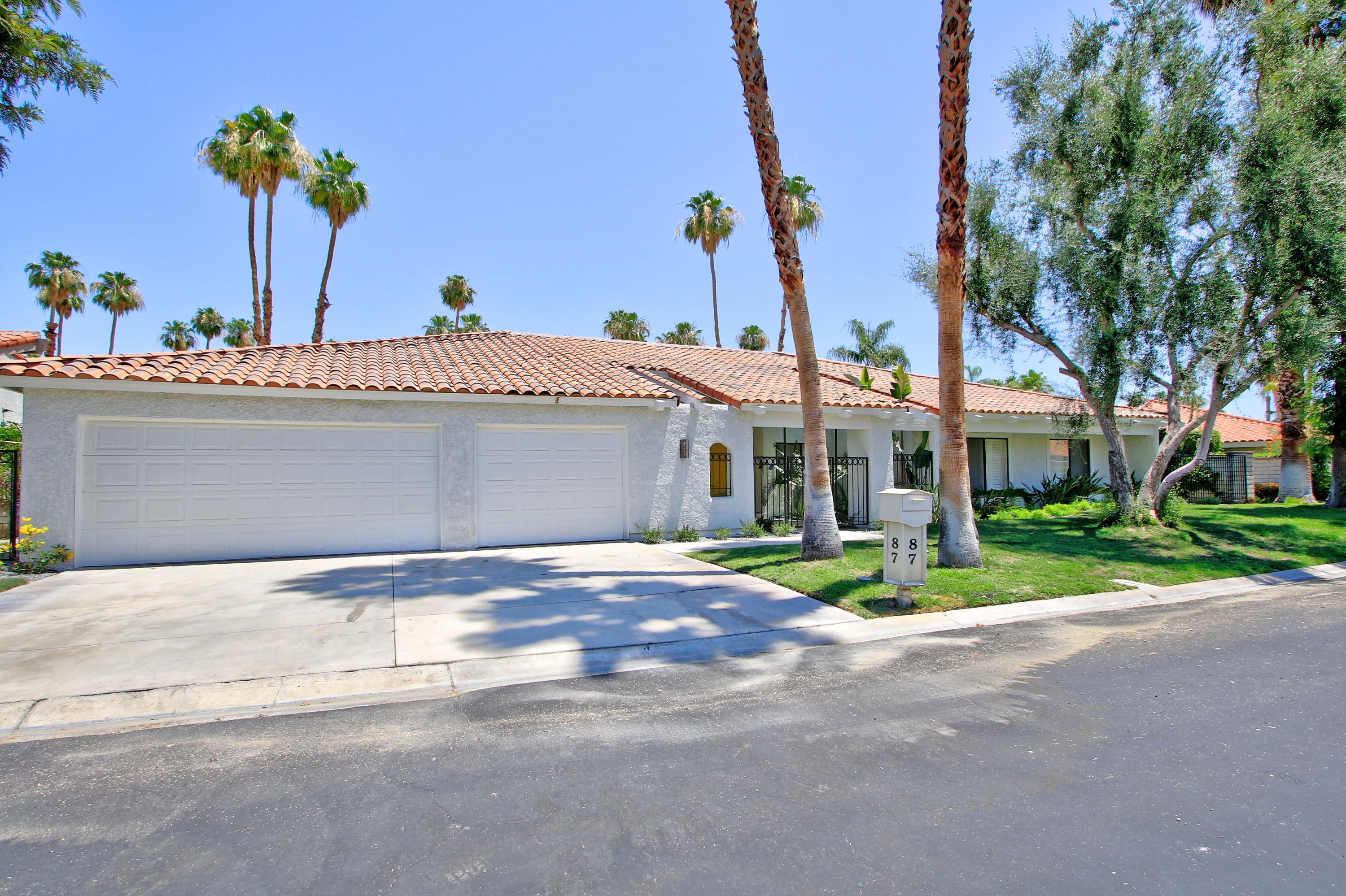 87 Magdalena Drive Rancho Mirage, CA 92270 - Photo 53 of 64 a front view of a house with a garden and yard