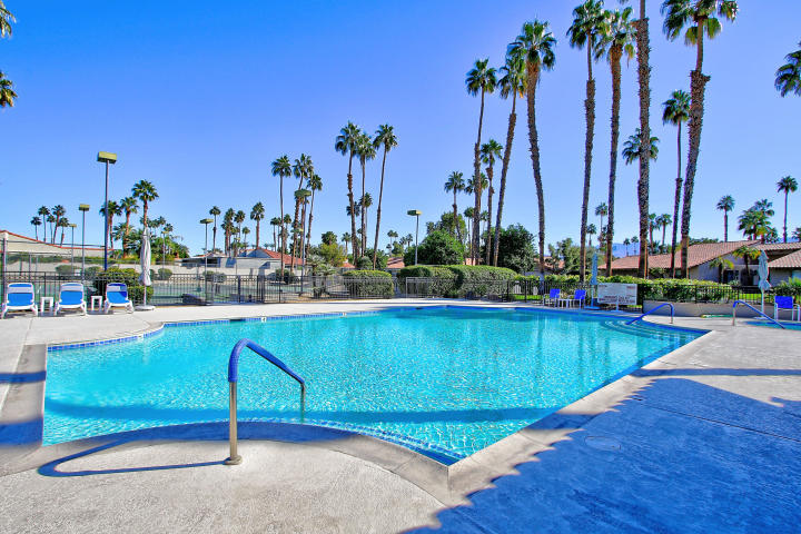87 Magdalena Drive Rancho Mirage, CA 92270 - Photo 54 of 64 a view of a swimming pool with a lawn chairs and palm tree