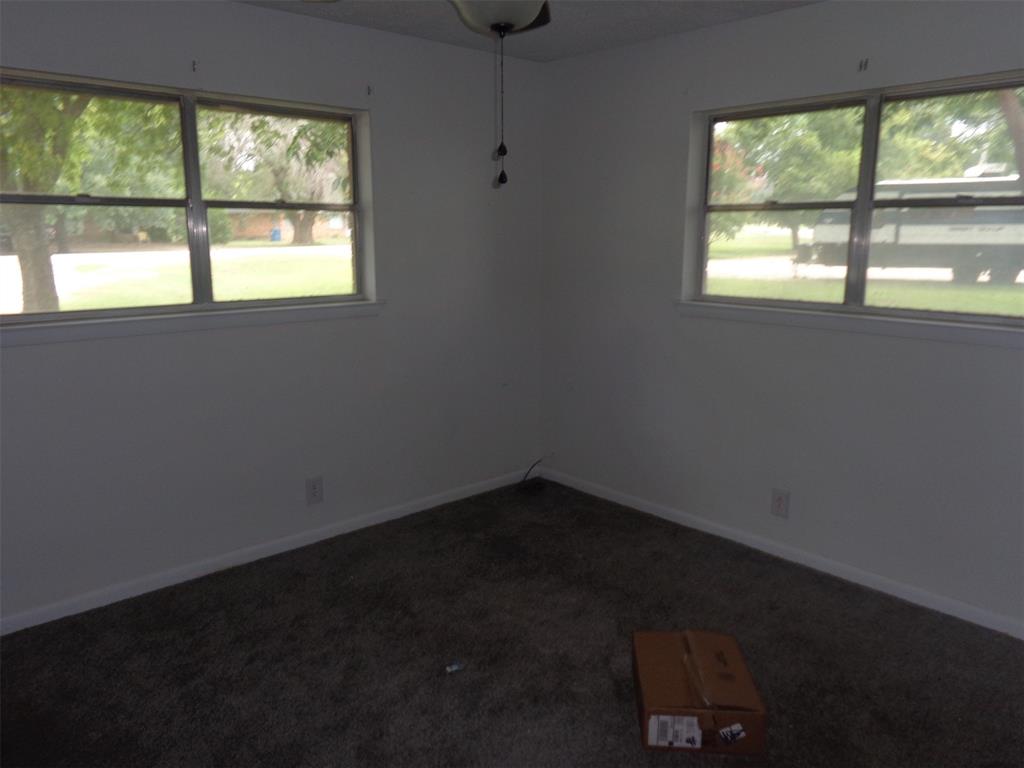 612 South Files Street Itasca, TX 76055 - Photo 22 of 30 Empty room featuring dark carpet and baseboards