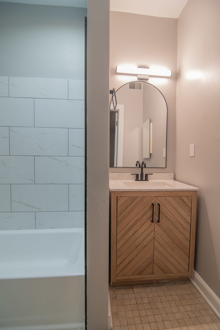 844 West Lakeside Place, Unit 1W Chicago, IL 60640 - Photo 12 of 14 a bathroom with a shower sink and mirror