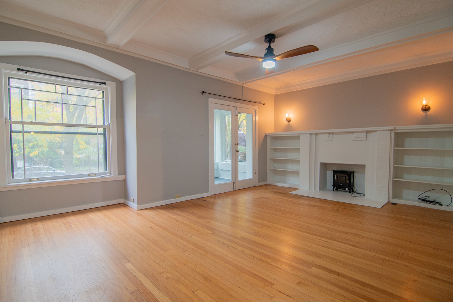 844 West Lakeside Place, Unit 1W Chicago, IL 60640 - Photo 2 of 14 a view of an empty room with wooden floor fireplace and a window