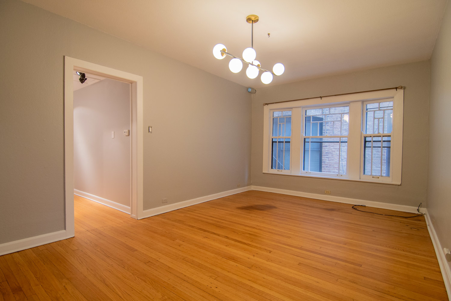 844 West Lakeside Place, Unit 1W Chicago, IL 60640 - Photo 6 of 14 a view of an empty room with wooden floor and a window