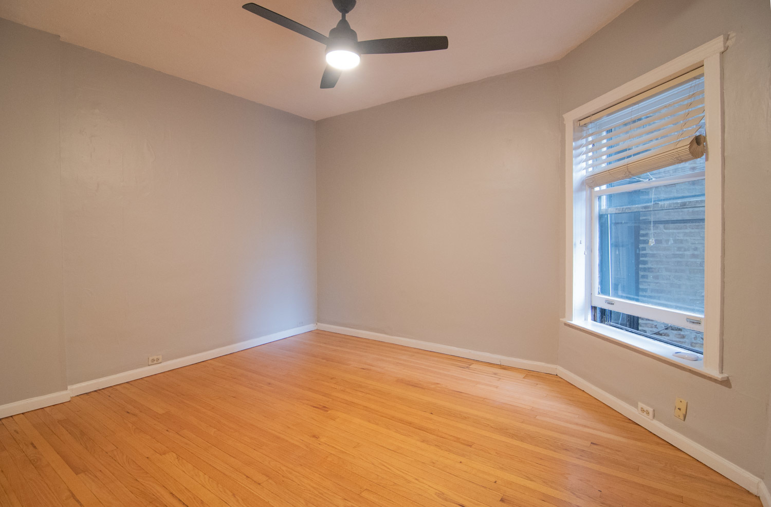 844 West Lakeside Place, Unit 1W Chicago, IL 60640 - Photo 7 of 14 an empty room with a window and ceiling fan