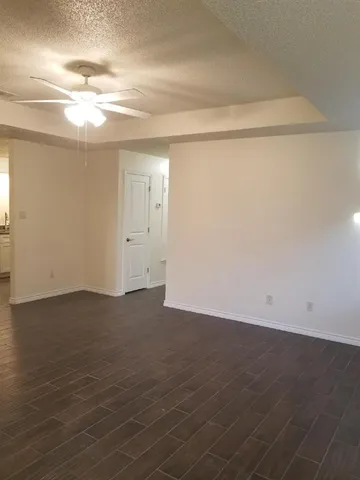 an empty room with wooden floor and windows in it