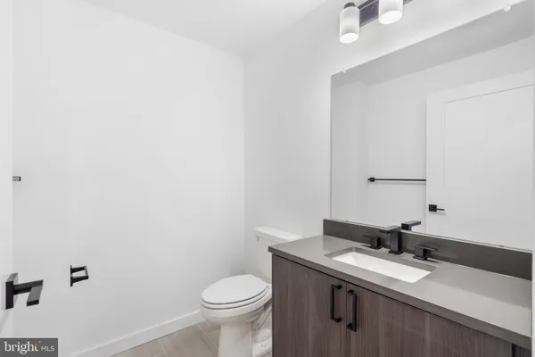 a bathroom with a granite countertop sink a toilet and a mirror