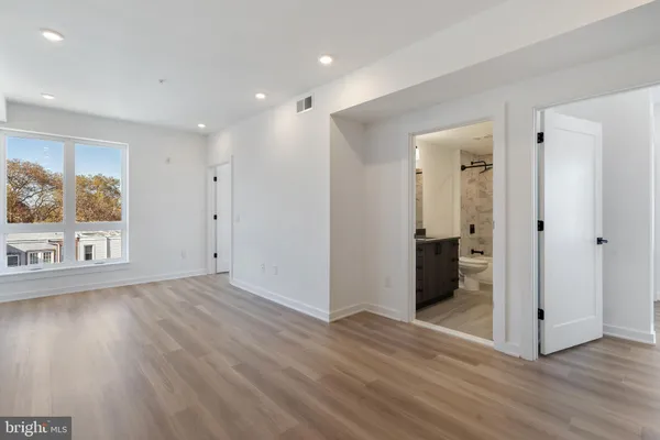 a view of a big room with wooden floor and windows