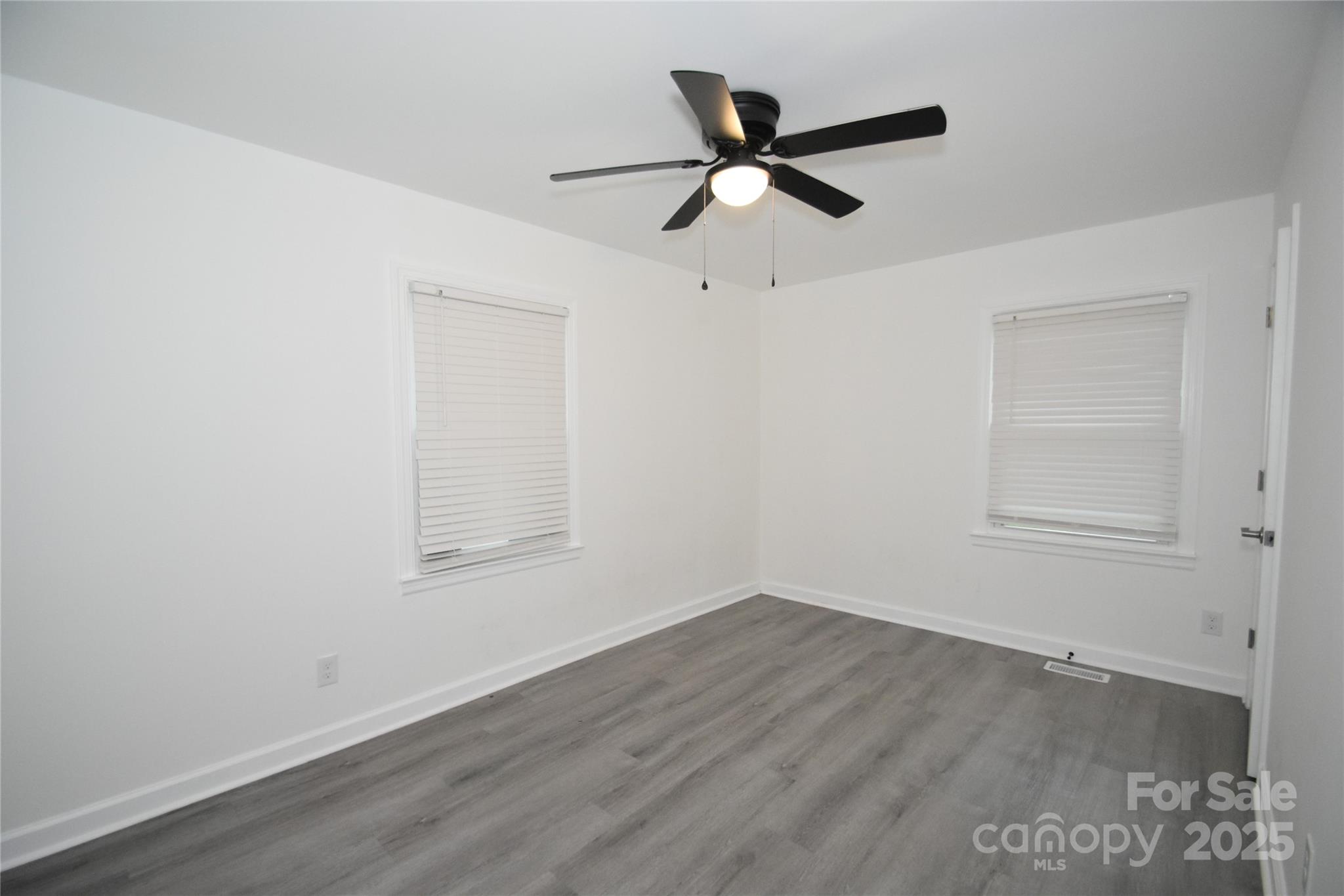 706 McIntyre Street Monroe, NC 28110 - Photo 13 of 20 a view of a big room with wooden floor closet and windows