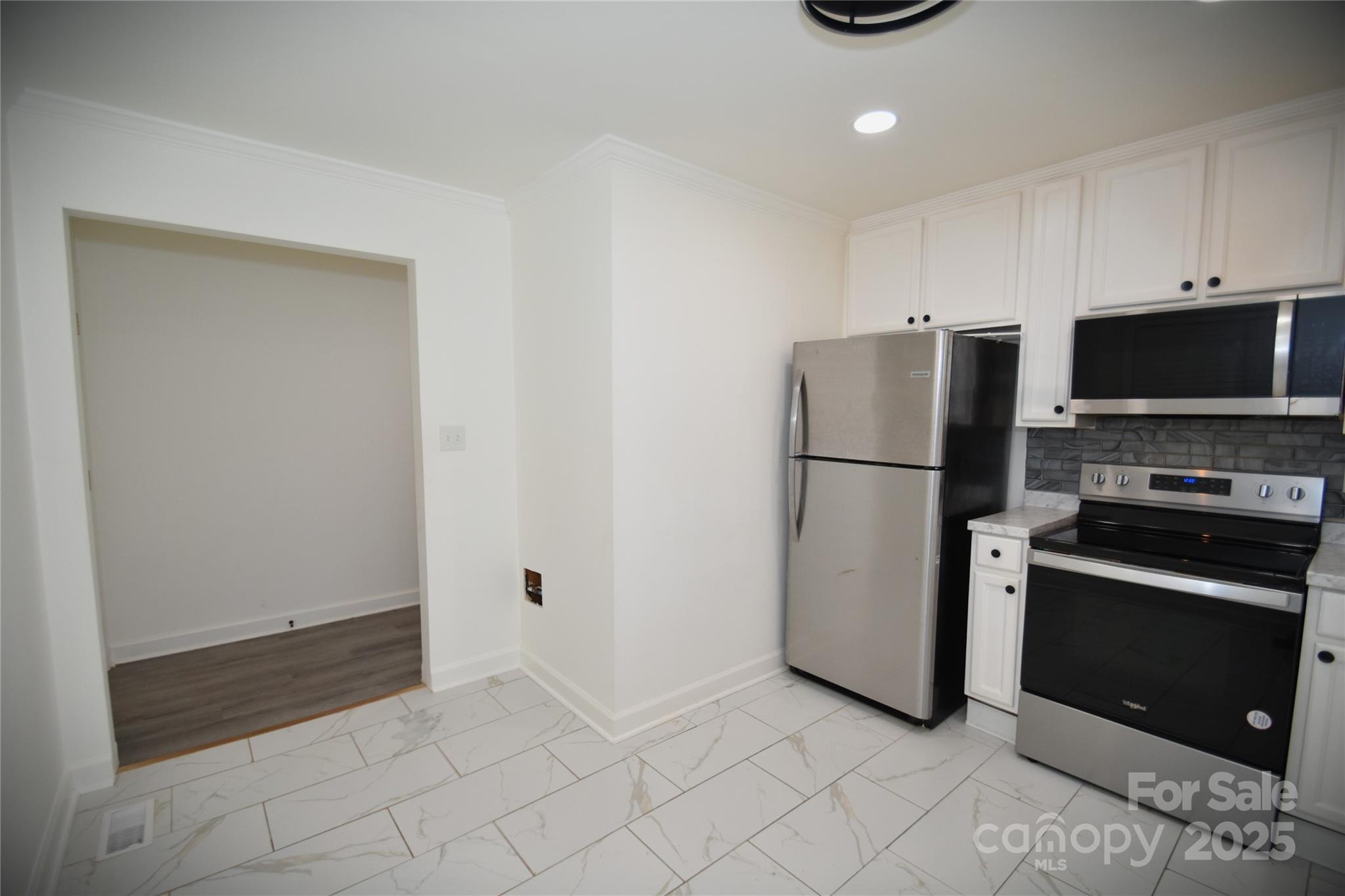 706 McIntyre Street Monroe, NC 28110 - Photo 10 of 20 a kitchen with a refrigerator and a stove