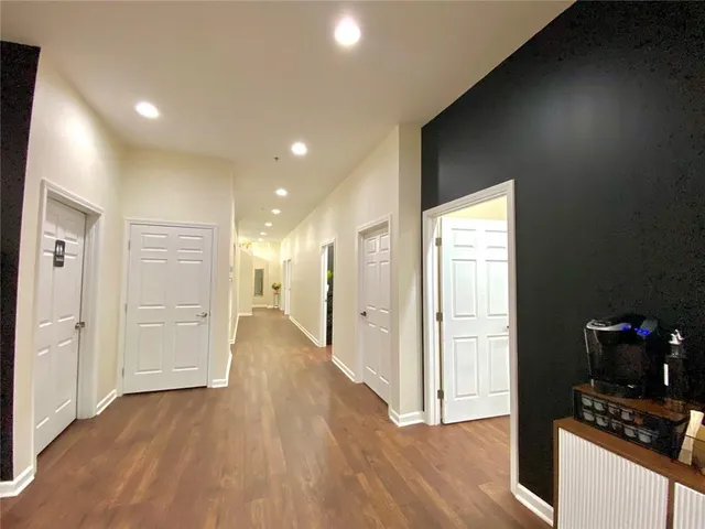 a view of a hallway with wooden floor and a cabinet