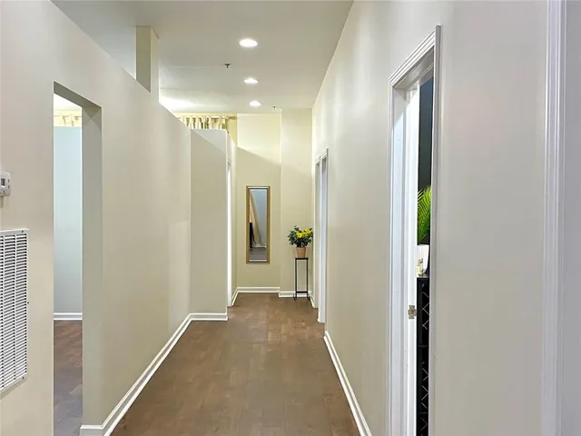 a view of hallway with livingroom and wooden floor