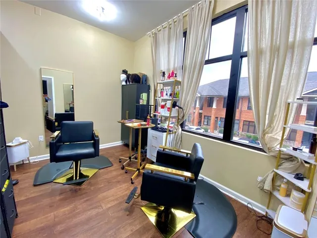 a view of a workspace with furniture and a window