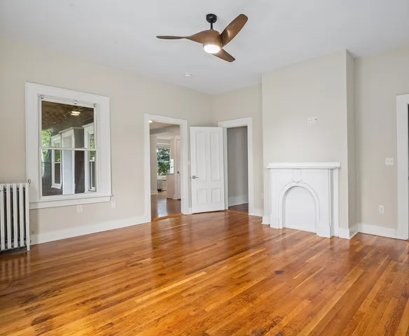 a view of a livingroom with wooden floor and a ceiling fan