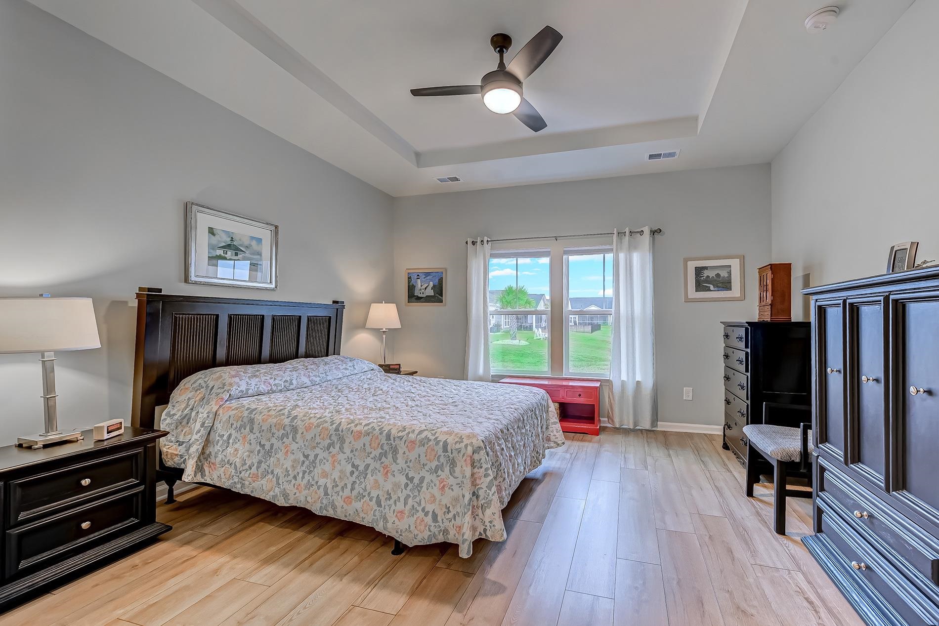 3016 Sistine Street Myrtle Beach, SC 29579 - Photo 15 of 39 Bedroom featuring light wood finished floors, a tray ceiling, and ceiling fan