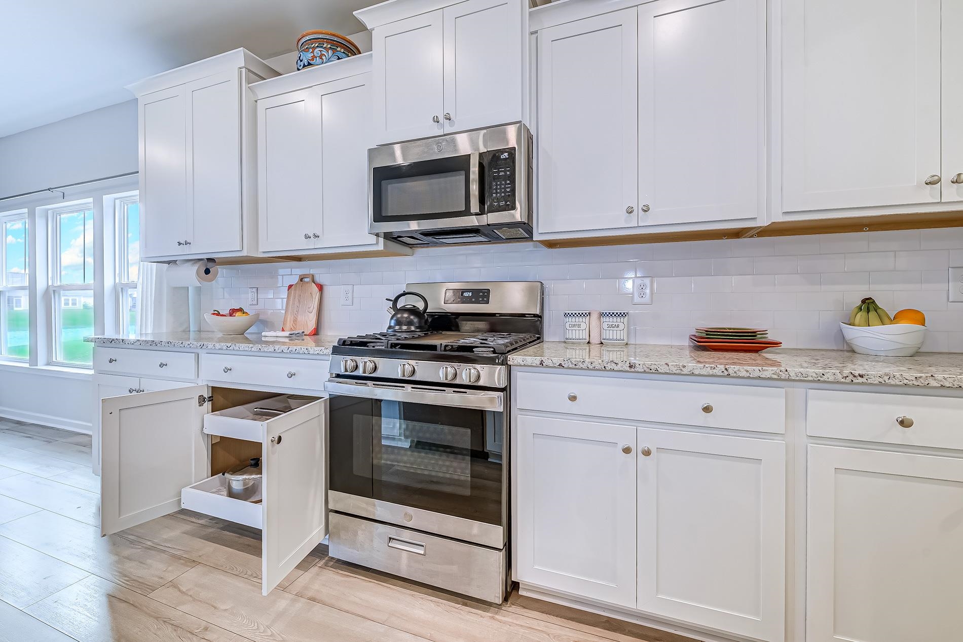 3016 Sistine Street Myrtle Beach, SC 29579 - Photo 25 of 39 Kitchen with appliances with stainless steel finishes, white cabinets, light stone countertops, light wood-type flooring, and backsplash