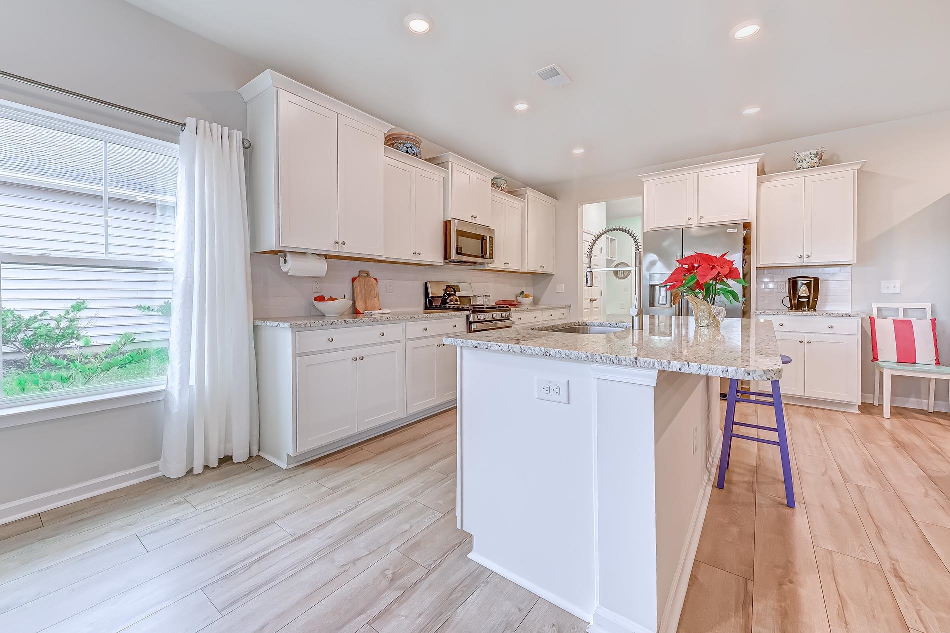 3016 Sistine Street Myrtle Beach, SC 29579 - Photo 26 of 39 Kitchen with white cabinets, light stone countertops, a center island with sink, and recessed lighting