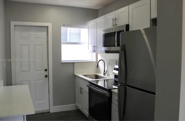 a kitchen with stainless steel appliances a refrigerator sink and microwave