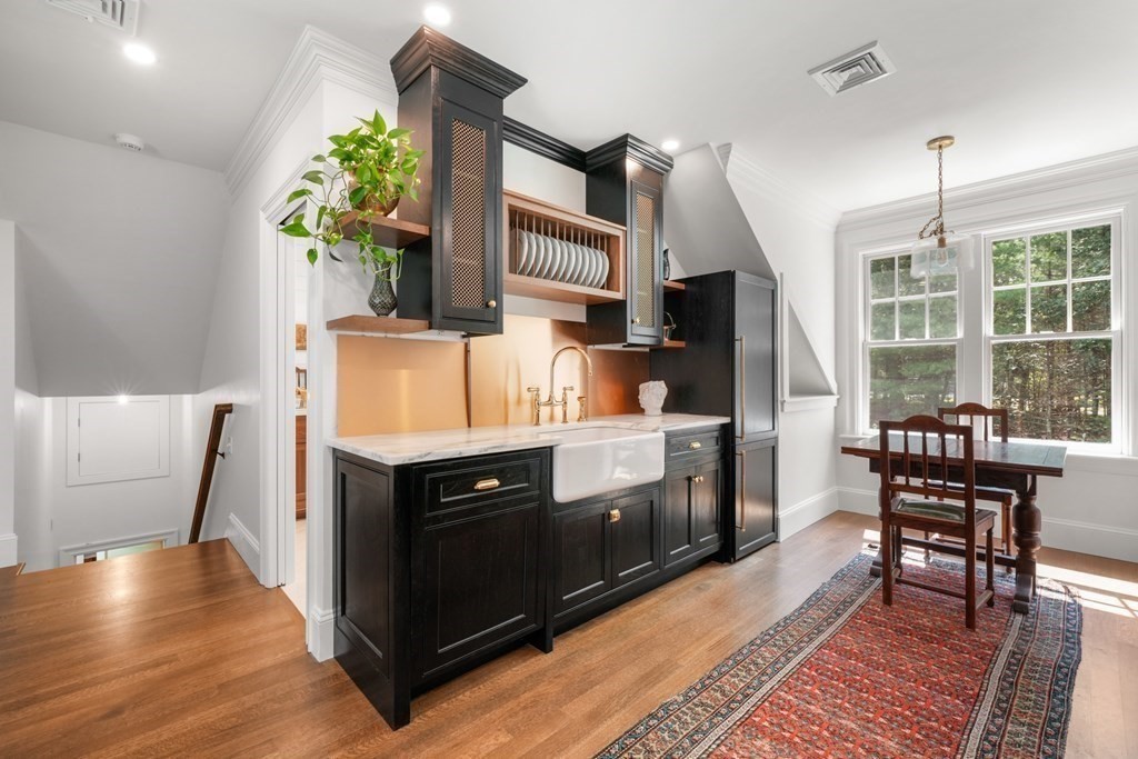 111 Lake Street Sherborn, MA 01770 - Photo 31 of 41 a kitchen with stainless steel appliances a stove a chimney a sink and a dining table