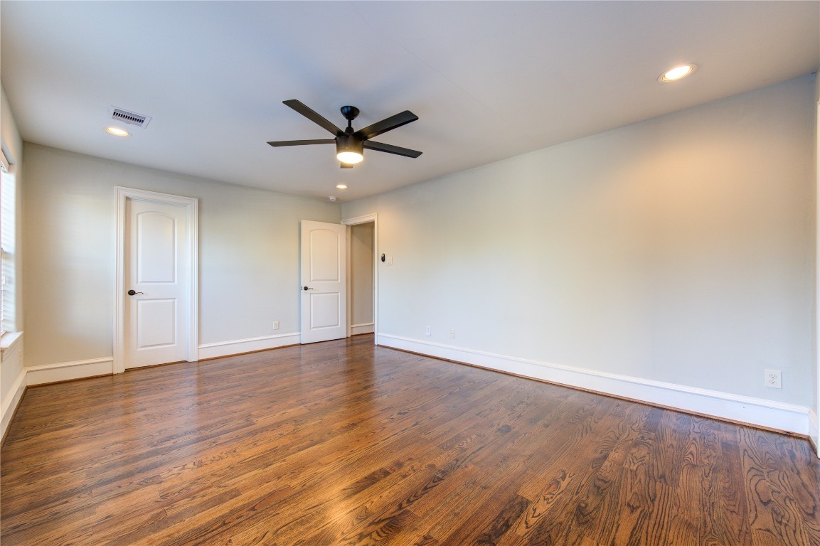 5226 Kiam Street, Unit 1015 Houston, TX 77007 - Photo 13 of 49 an empty room with wooden floor and a ceiling fan