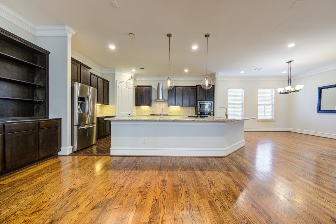5226 Kiam Street, Unit 1015 Houston, TX 77007 - Photo 21 of 49 a large kitchen with stainless steel appliances kitchen island a large counter top and a wooden floors