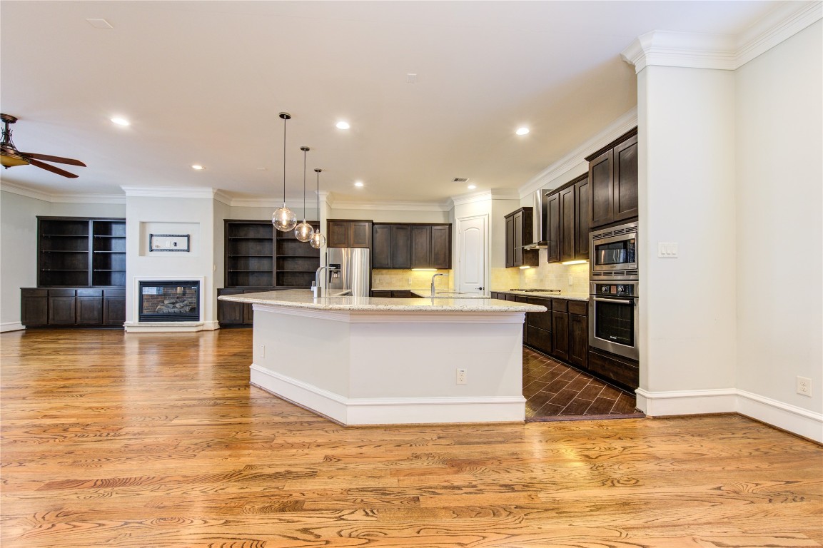 5226 Kiam Street, Unit 1015 Houston, TX 77007 - Photo 24 of 49 a large kitchen with stainless steel appliances kitchen island a large counter top and a wooden floors