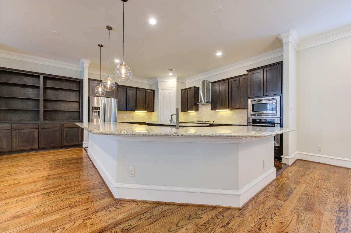 5226 Kiam Street, Unit 1015 Houston, TX 77007 - Photo 28 of 49 a view of kitchen with kitchen island microwave and wooden floor