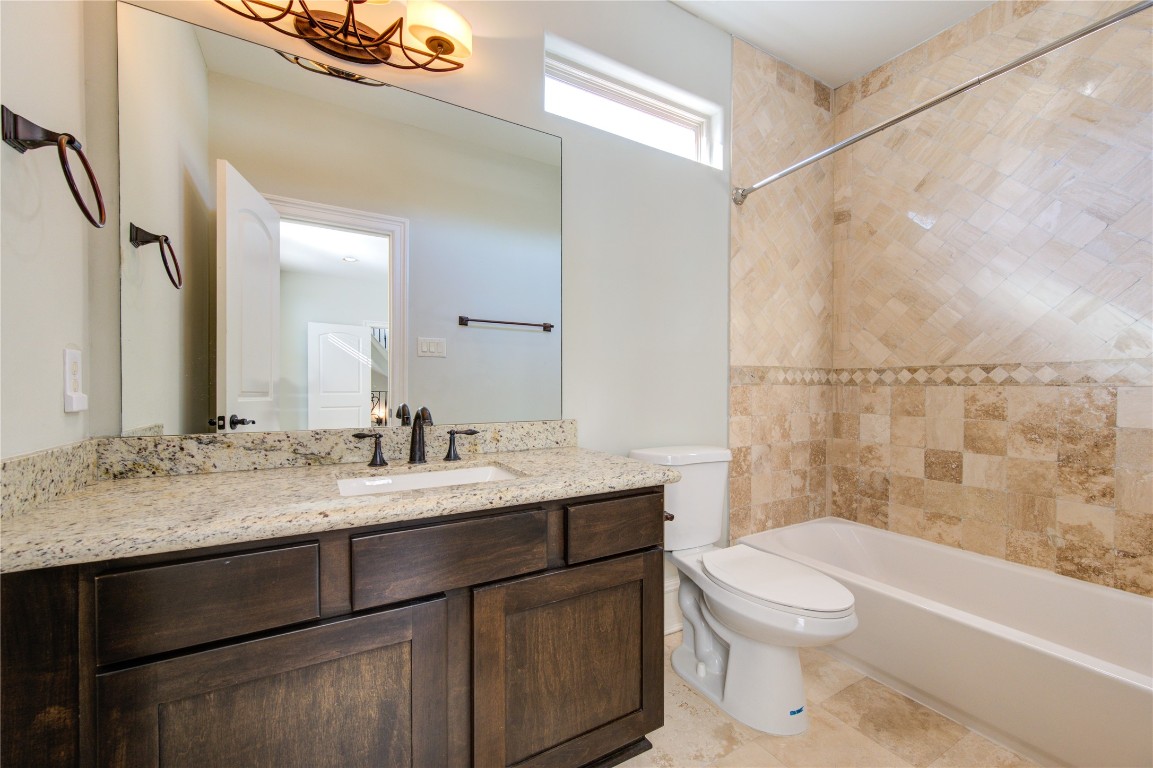 5226 Kiam Street, Unit 1015 Houston, TX 77007 - Photo 37 of 49 a bathroom with a granite countertop sink mirror vanity and toilet