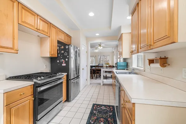 a kitchen with granite countertop a stove a sink and a refrigerator