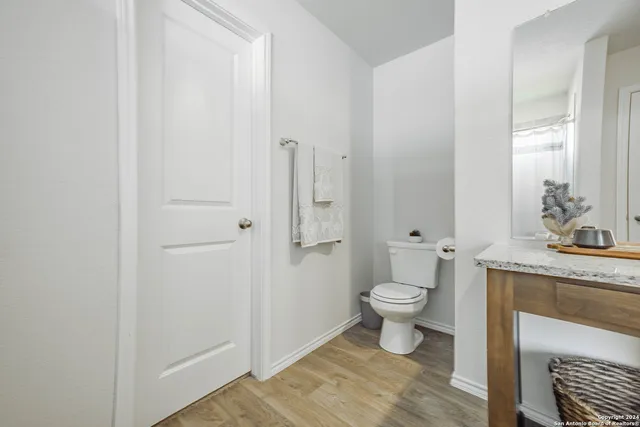 a bathroom with a granite countertop toilet a sink and a mirror