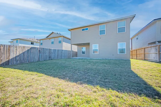 a view of a backyard with wooden fence