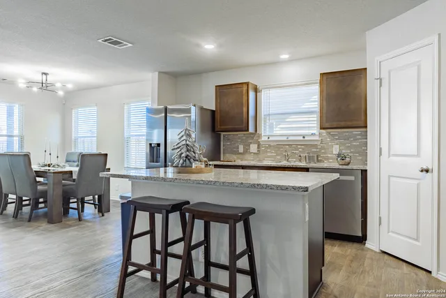 a kitchen with center island table and chairs
