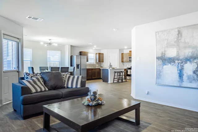 a living room with furniture and a wooden floor