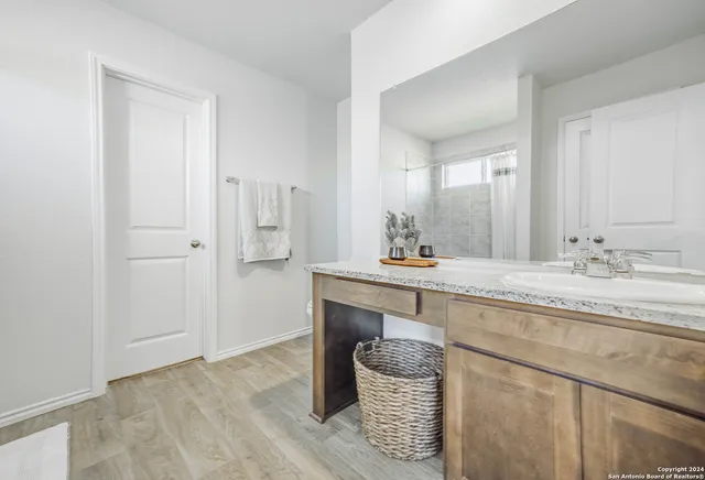 a bathroom with a granite countertop sink and a mirror