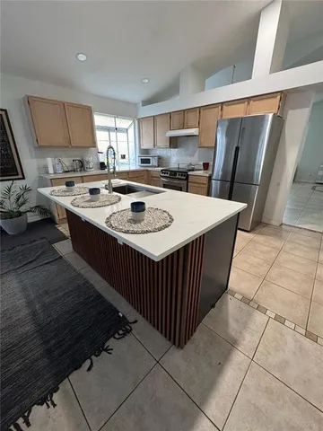 a kitchen with stainless steel appliances granite countertop a stove a sink a refrigerator and a refrigerator