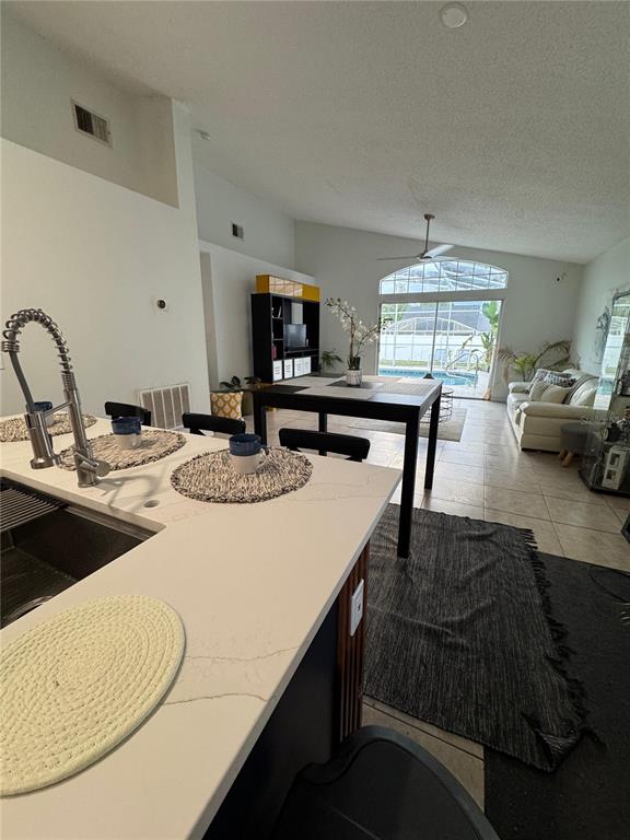 2512 Asbury Court Kissimmee, FL 34746 - Photo 12 of 12 a kitchen with kitchen island a stove a sink a dining table and chairs